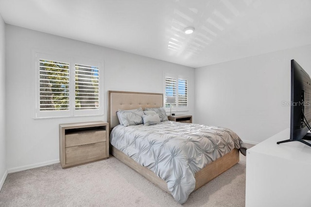 bedroom featuring light colored carpet and baseboards