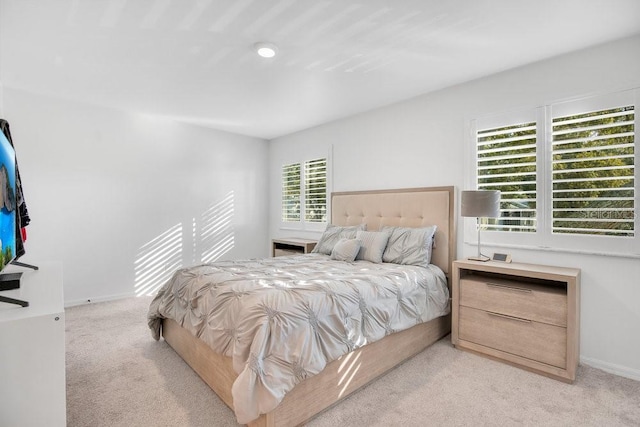 bedroom featuring light colored carpet and baseboards