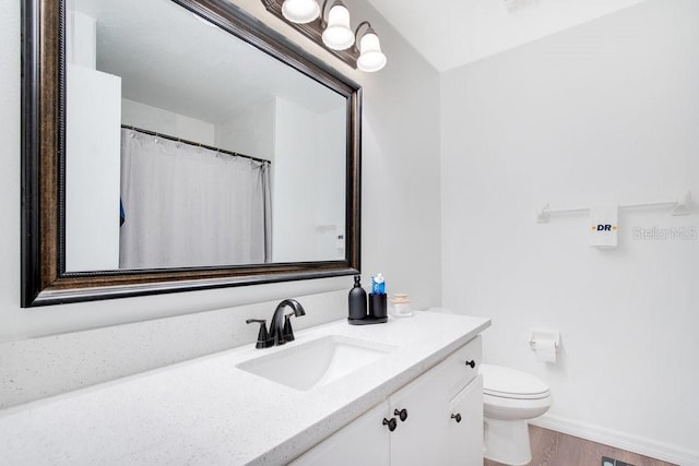 bathroom with hardwood / wood-style flooring, vanity, and toilet