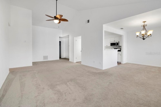 unfurnished living room featuring light carpet, visible vents, and ceiling fan with notable chandelier