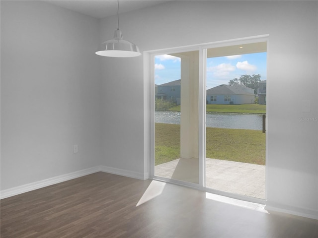 unfurnished dining area with a water view and hardwood / wood-style flooring