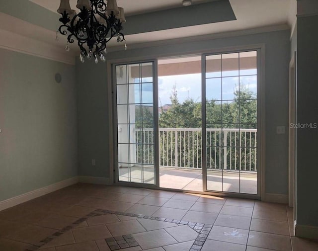 tiled spare room featuring a notable chandelier