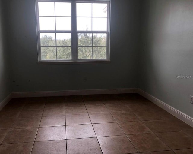 unfurnished room with tile patterned flooring and a healthy amount of sunlight