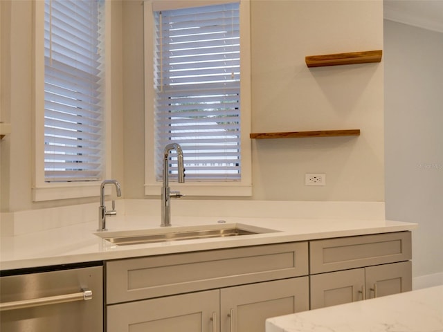 kitchen featuring dishwasher, light stone countertops, and sink