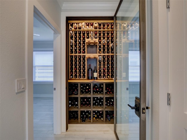 wine cellar with crown molding and light hardwood / wood-style floors