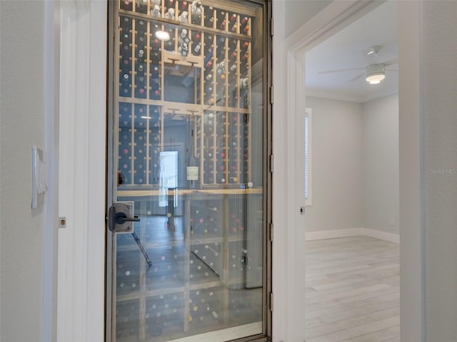 wine room featuring crown molding, ceiling fan, and wood-type flooring