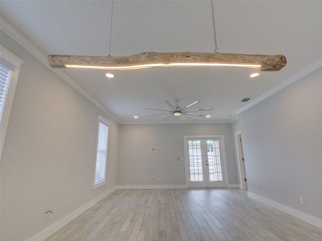 spare room featuring french doors, light wood-type flooring, ceiling fan, and ornamental molding