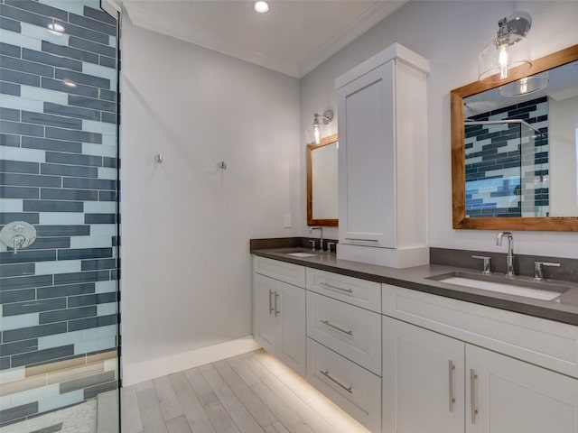 bathroom featuring vanity, tiled shower, and crown molding