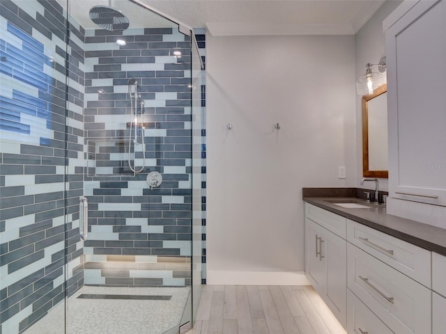 bathroom featuring vanity, an enclosed shower, and ornamental molding