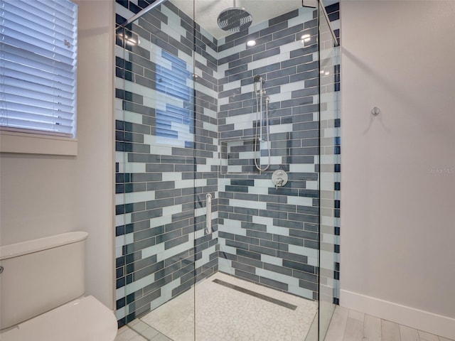 bathroom featuring a tile shower and toilet