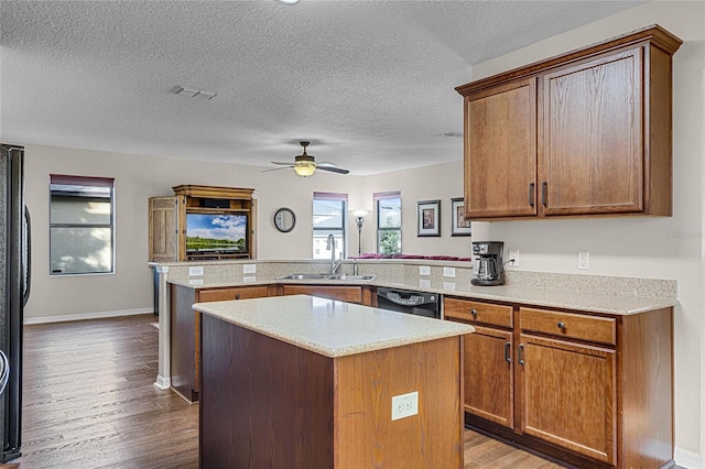 kitchen with a kitchen island, kitchen peninsula, hardwood / wood-style flooring, and sink