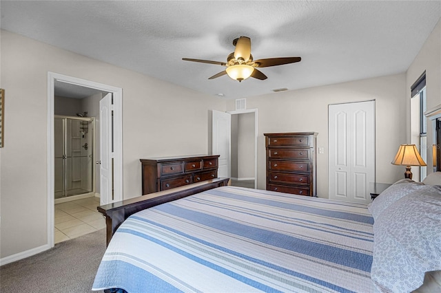 carpeted bedroom featuring ceiling fan, ensuite bathroom, a closet, and a textured ceiling