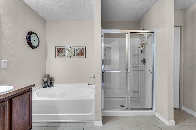 bathroom with a textured ceiling, vanity, tile patterned floors, and shower with separate bathtub