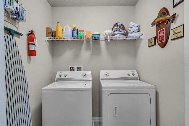 laundry room with washer and dryer and a textured ceiling