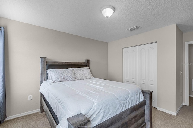 carpeted bedroom with a closet and a textured ceiling