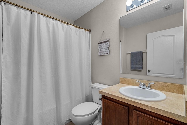 bathroom featuring a textured ceiling, vanity, and toilet