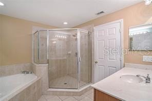 bathroom with tile patterned flooring, vanity, and independent shower and bath