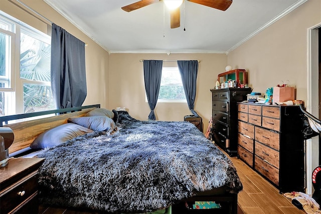 bedroom featuring hardwood / wood-style flooring, ceiling fan, and crown molding