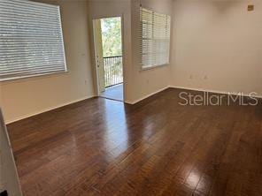 empty room with dark hardwood / wood-style flooring