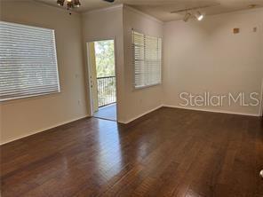 spare room with track lighting, crown molding, and dark wood-type flooring