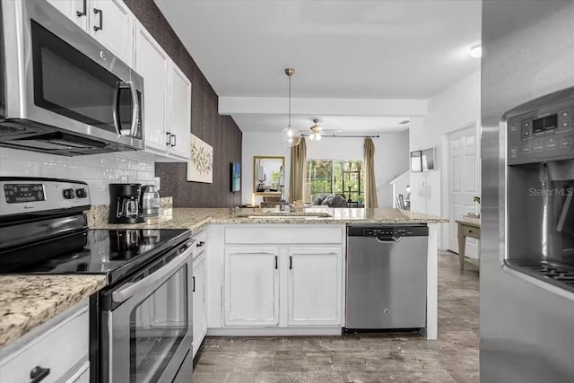 kitchen with white cabinetry, ceiling fan, light stone countertops, kitchen peninsula, and appliances with stainless steel finishes