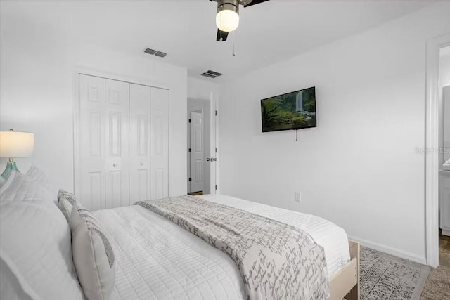 carpeted bedroom with ceiling fan and a closet