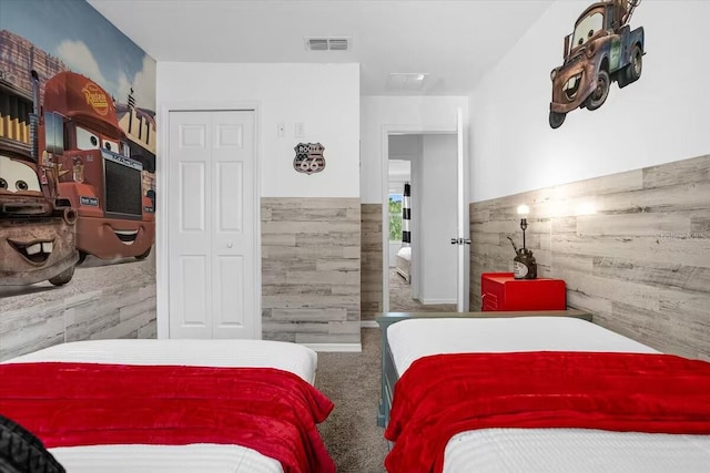 carpeted bedroom with wooden walls