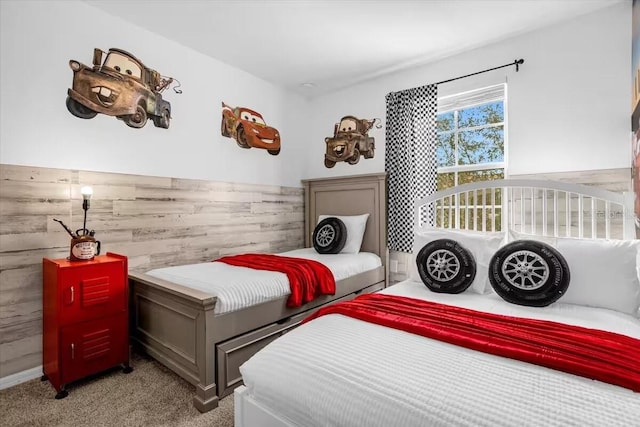 carpeted bedroom featuring wooden walls