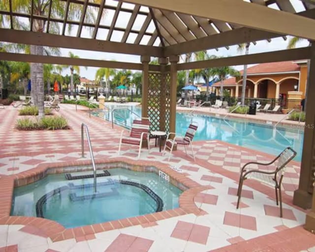 view of pool with a patio area and a hot tub