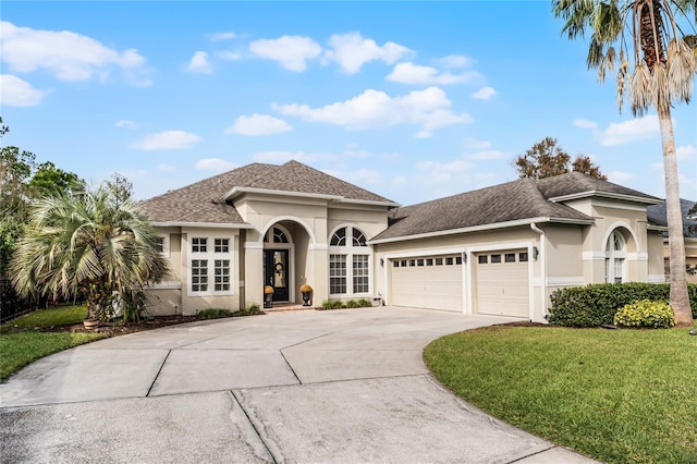 mediterranean / spanish-style home with a front yard and a garage