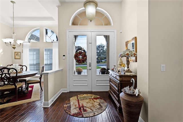 entryway with a notable chandelier, dark hardwood / wood-style flooring, and french doors