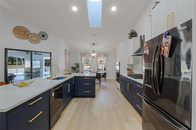 kitchen featuring stainless steel appliances, hanging light fixtures, a large island, and sink