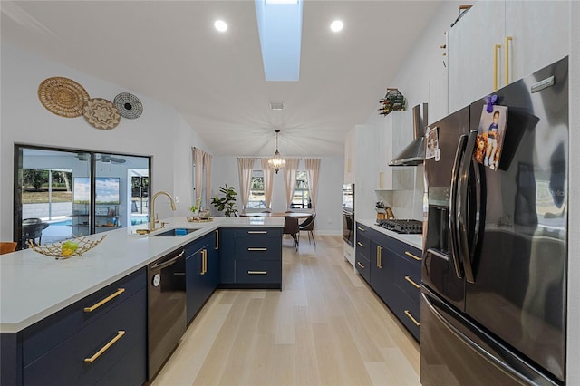 1681 E Evelyn St, Hernando, FL 34442 - kitchen with stainless steel appliances, wall chimney range hood, light countertops, light wood-style floors, and lofted ceiling