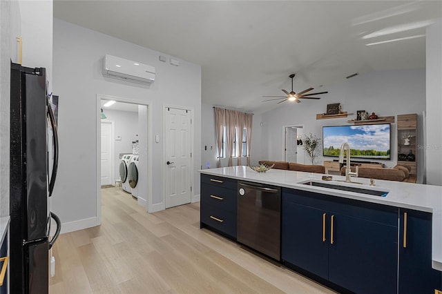 kitchen featuring black refrigerator, an AC wall unit, sink, stainless steel dishwasher, and washer and dryer