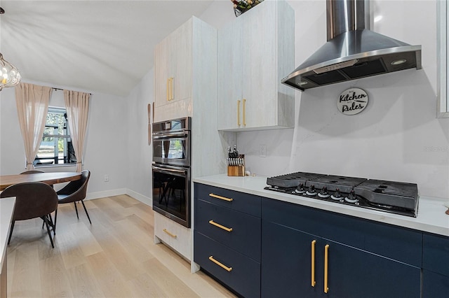 kitchen with gas cooktop, blue cabinets, island range hood, double wall oven, and light wood-type flooring