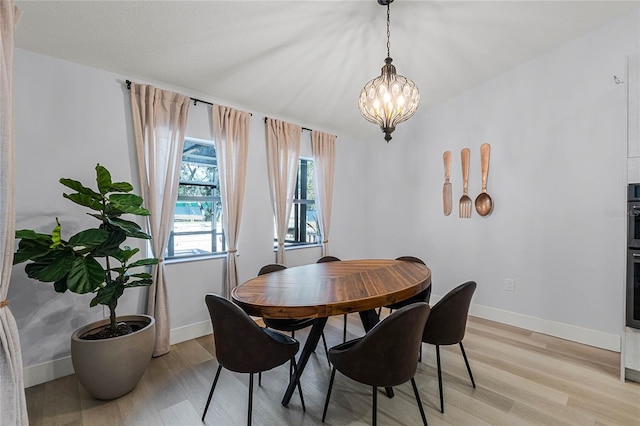 dining area featuring a chandelier and light hardwood / wood-style floors