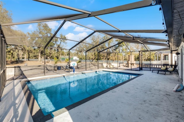 view of swimming pool with glass enclosure and a patio area