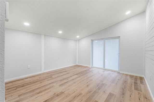 unfurnished room with lofted ceiling and light hardwood / wood-style flooring