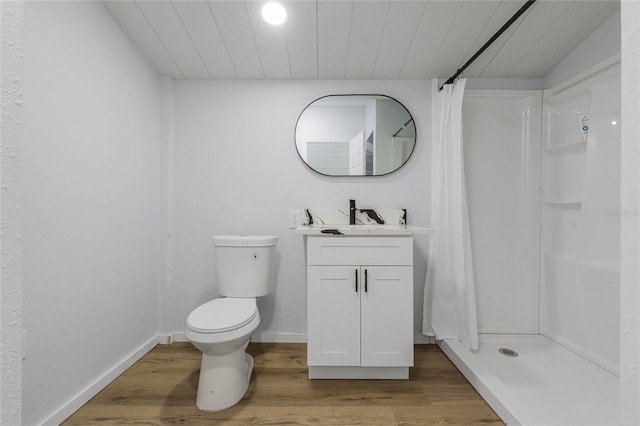 bathroom with hardwood / wood-style floors, a shower with curtain, toilet, and vanity