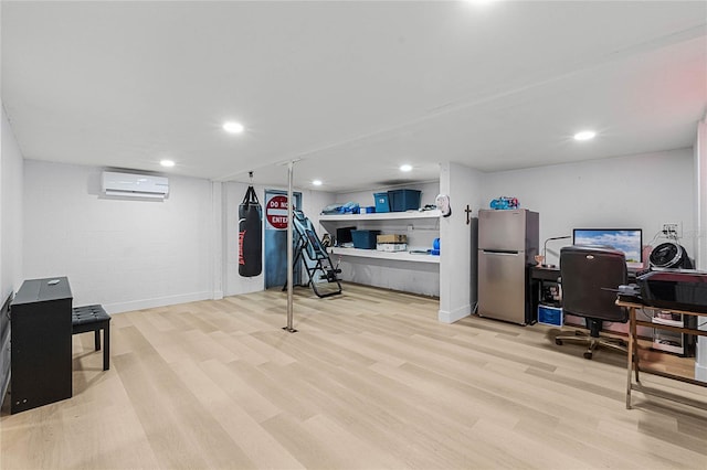 home office featuring light hardwood / wood-style floors and a wall unit AC