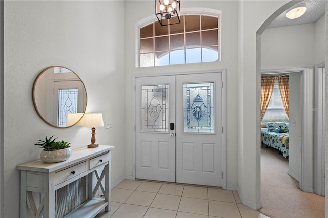 entryway featuring light tile patterned floors and a chandelier