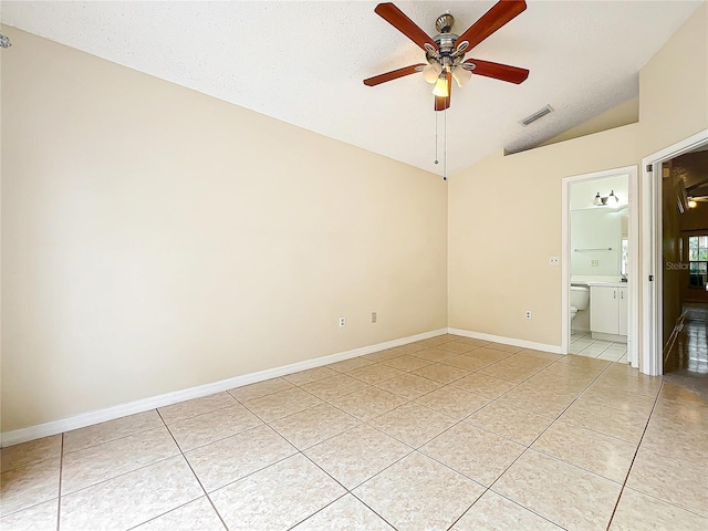 empty room with light tile patterned floors, vaulted ceiling, and ceiling fan