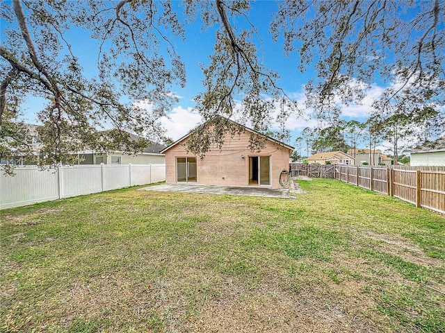 back of house featuring a patio area and a lawn