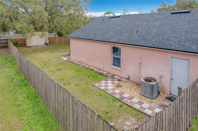 view of yard with central AC unit and a storage unit