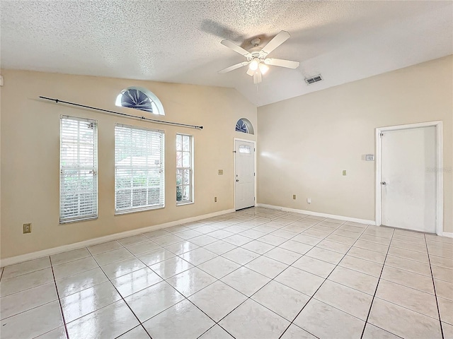 tiled empty room featuring lofted ceiling, a textured ceiling, and ceiling fan