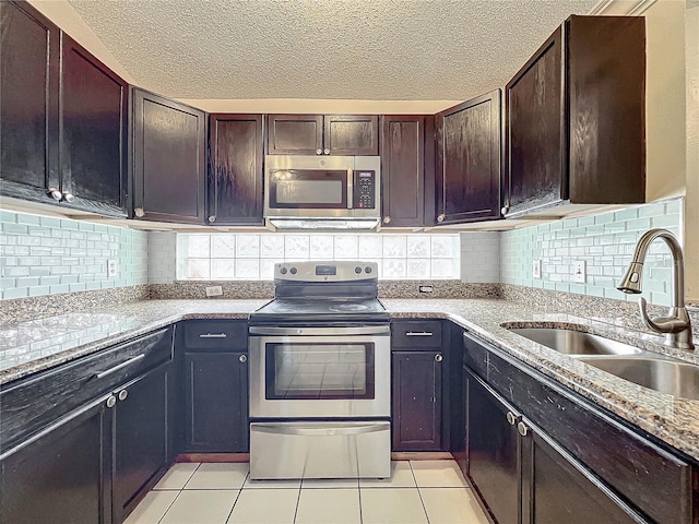 kitchen featuring sink, light tile patterned floors, stainless steel appliances, and decorative backsplash