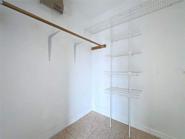 walk in closet featuring an AC wall unit and light tile patterned floors