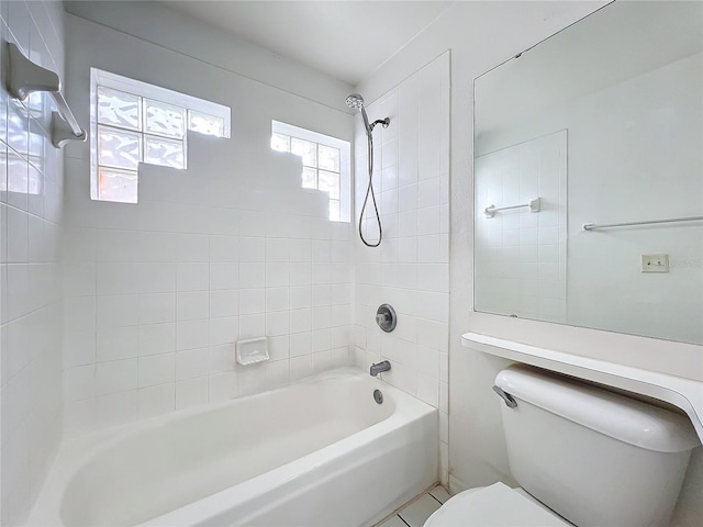 bathroom featuring toilet and tiled shower / bath