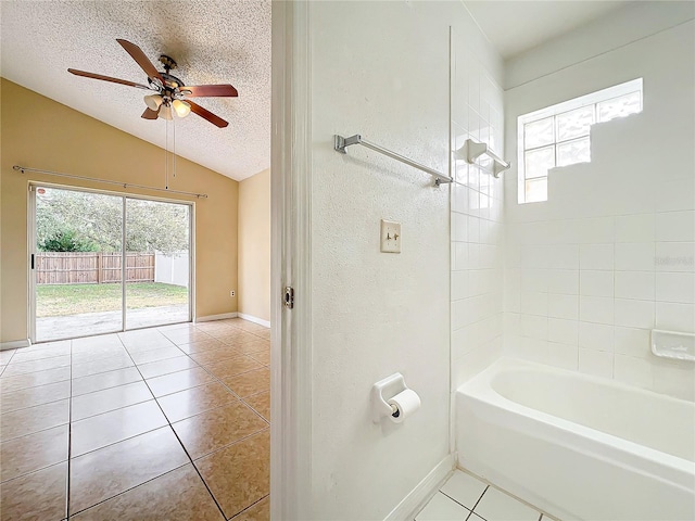 bathroom featuring lofted ceiling, tile patterned flooring, a textured ceiling, and a wealth of natural light