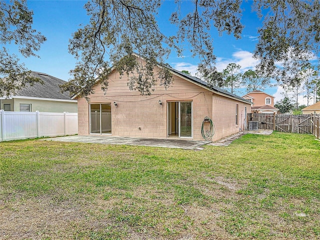 back of property featuring a yard, central AC unit, and a patio